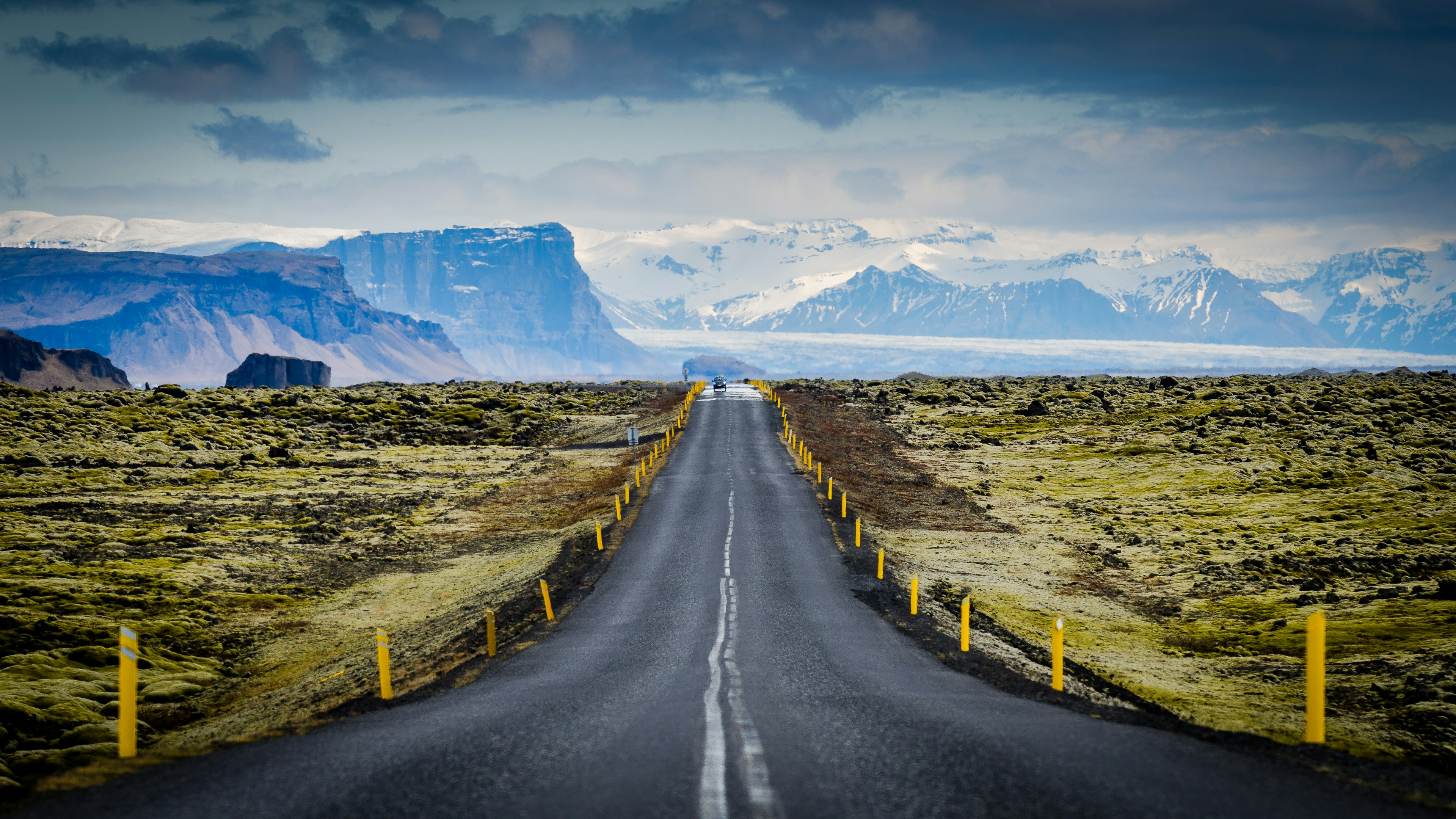 A road travels toward tall mountains